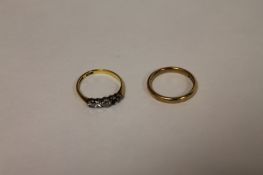 An 18ct gold three stone diamond ring, together with 9ct gold band ring. (2) The 18ct ring has