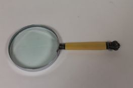A large magnifying glass with white metal mounts and ivorine grip. Good condition.