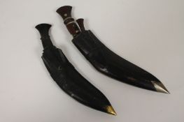 Two early twentieth century Kukri in leather scabbards. (2) Both blades early and in good condition,