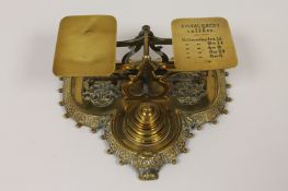 A set of cast brass postal scales by Townshend & Co, with weights, width 19 cm. Good condition.
