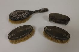 A silver dressing table pot, Chester 1906, together with three silver backed dressing table brushes.