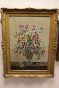 An embroidered panel in wool depicting a still life with flowers, 68 cm x 47 cm, together with