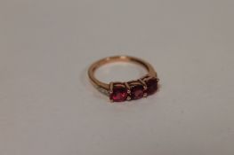 A 9ct gold three stone rubellite and diamond ring. Good condition.