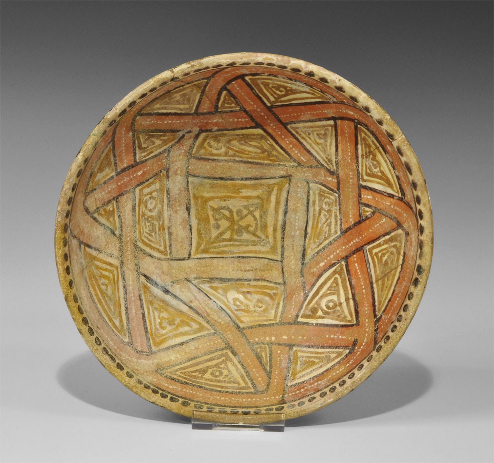 Islamic Cream-Glazed Bowl Fatimid, 12th century AD . A wide ceramic bowl with low basal ring, a
