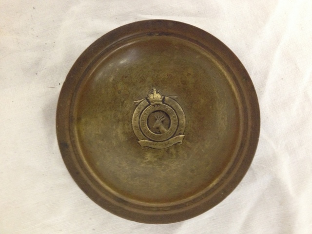 A brass ashtray with a South Africa Springbok embossed badge