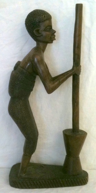 Large African carving of a woman grinding corn