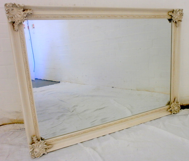 White swept framed mirror.