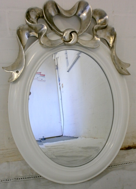 Oval mirror with silver bow.