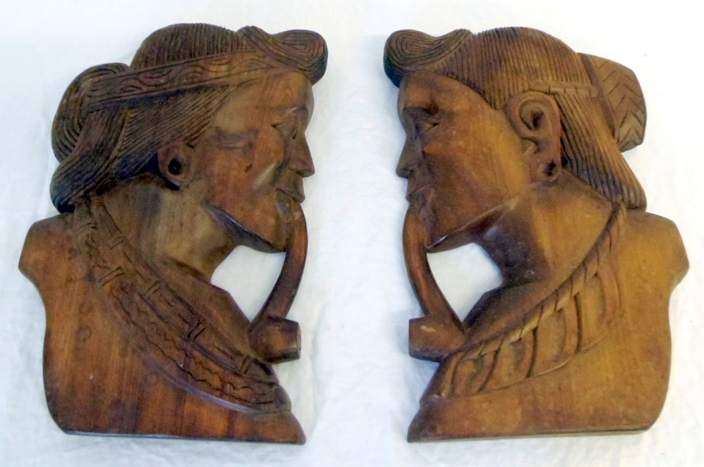 Pair of Indonesian carved wall hangings of heads.