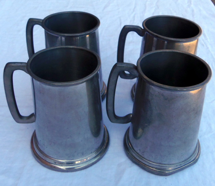 Four pewter tankards.