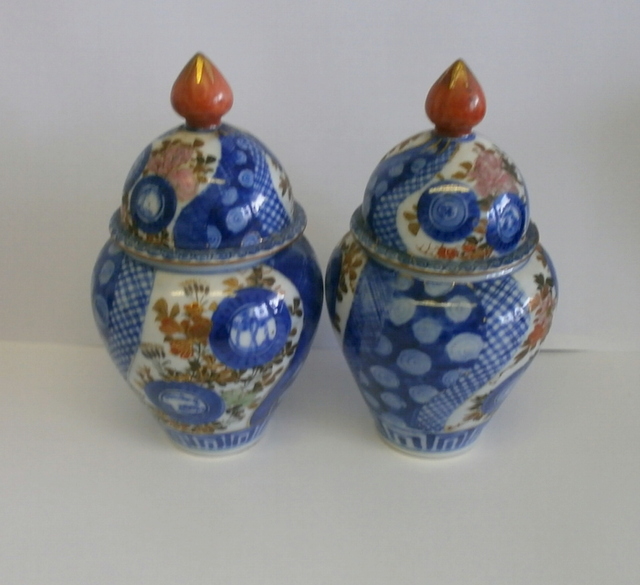 A pair of late 19th century lidded vases / urns