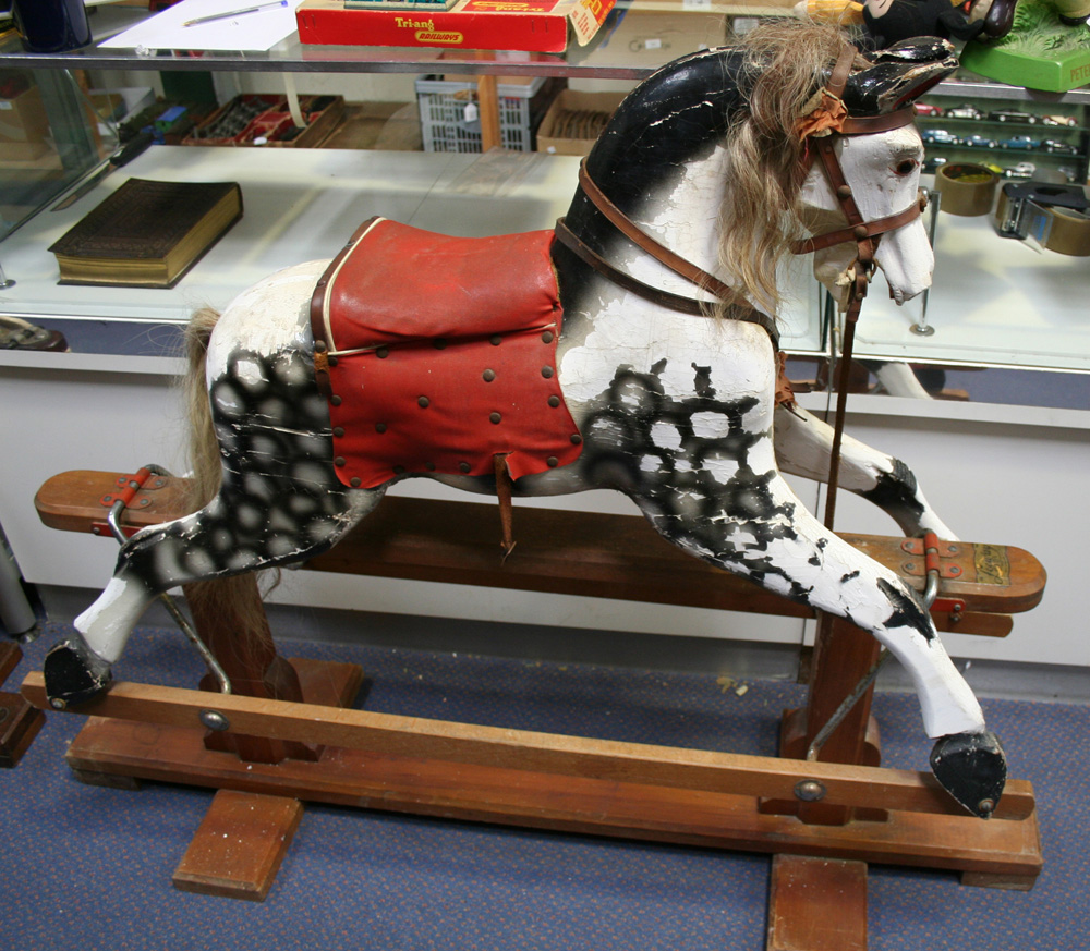 A Leeway dapple grey rocking horse with amber and black eyes, mane, tail, saddle and harness, on a