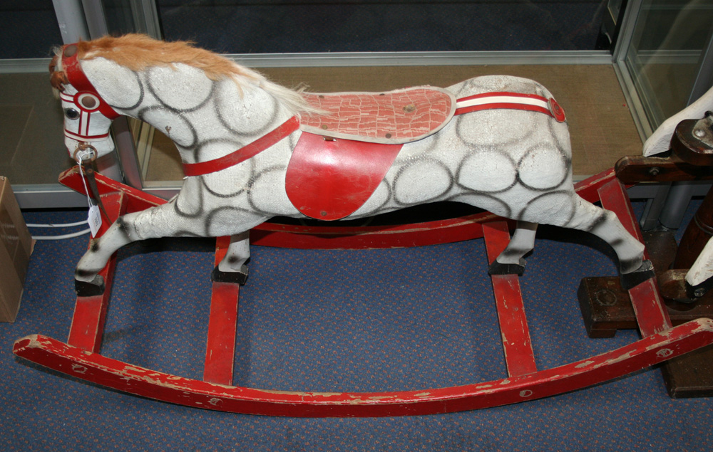 A painted fabric rocking horse with mane and saddle, on a red painted stand, overall length approx