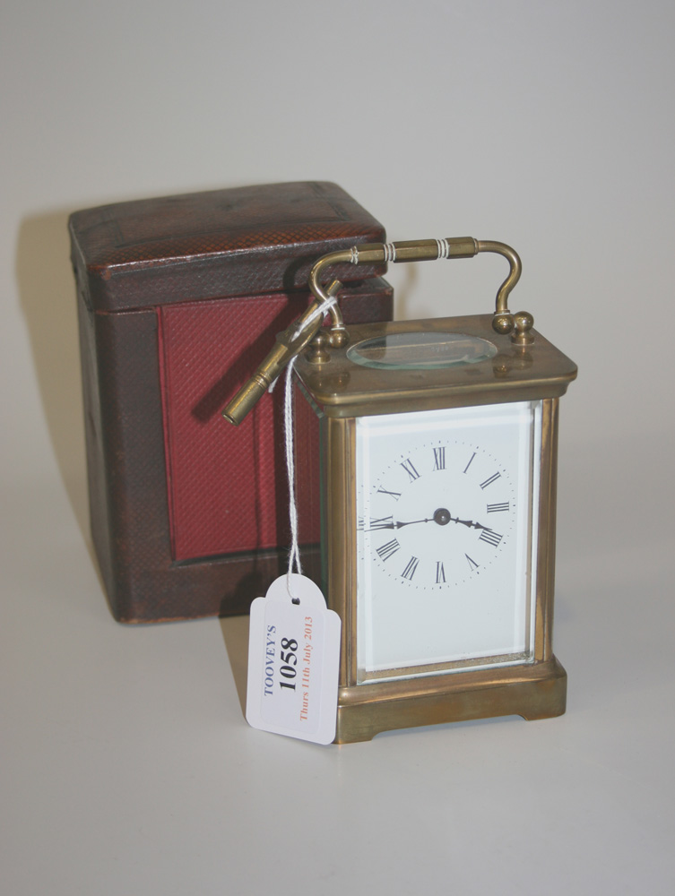 An early 20th Century brass cased carriage timepiece, the white enamel dial with Roman numerals, the