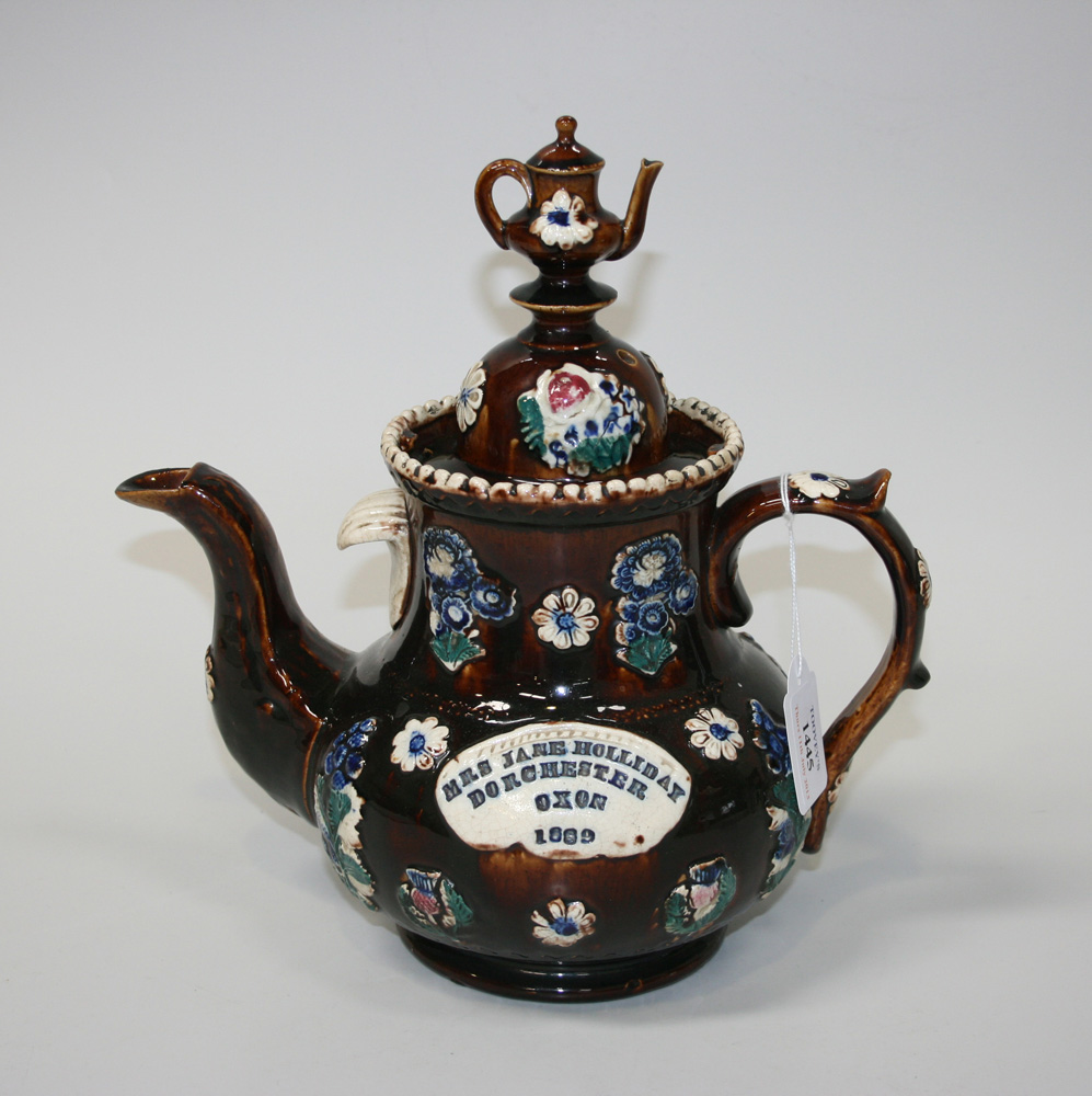 A Measham Bargeware teapot, late 19th Century, the lid with teapot finial above a typically