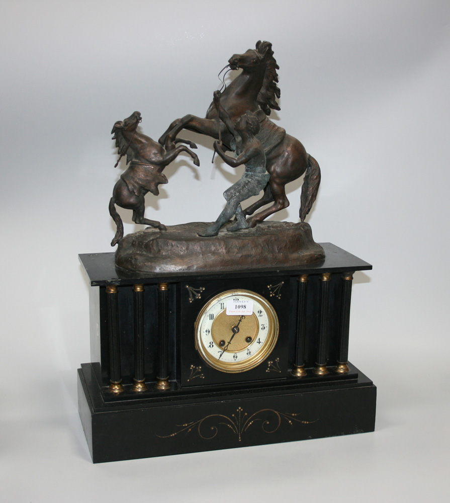 A late 19th Century slate mantel clock with eight day movement striking on a gong, the dial with