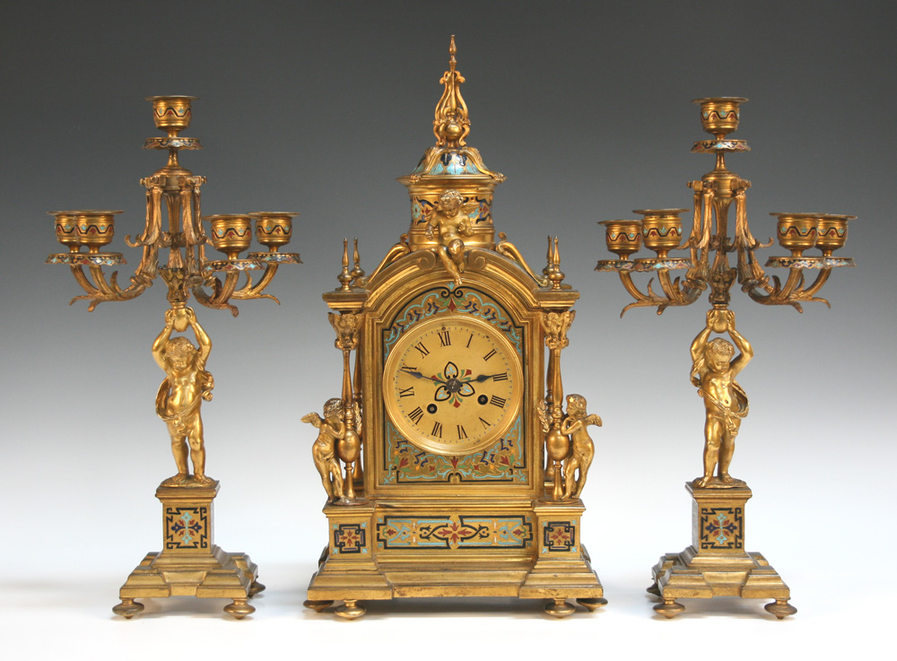 A late 19th Century French ormolu and champlevé enamel clock garniture, the clock with eight day