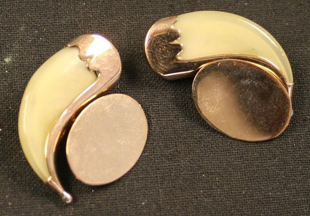 A pair of gold mounted tiger`s claw dress cufflinks with plain oval backs.