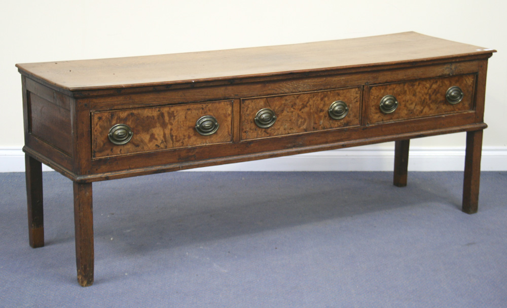 An 18th Century oak dresser base, fitted with three short drawers with pollard oak fronts, on