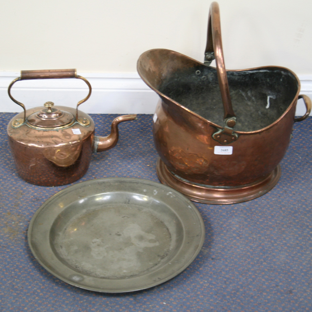 A collection of metalwork, including a copper kettle, a warming pan, a helmet coal scuttle, a lamp