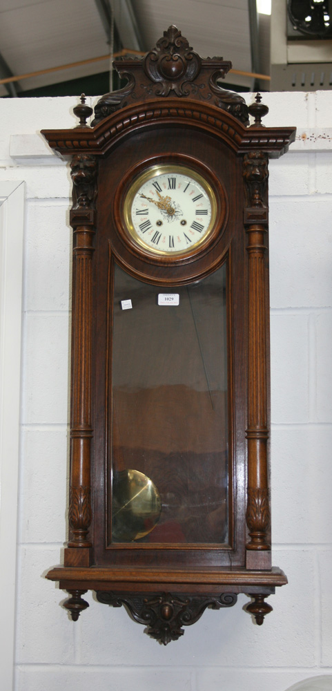 A late 19th Century walnut Vienna style wall clock with eight day movement striking on a gong, the