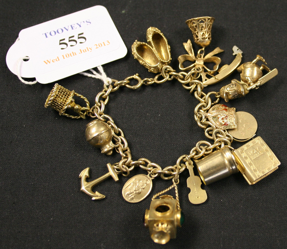A 9ct gold oval link charm bracelet with a boltring clasp, fitted with fourteen, pendants and