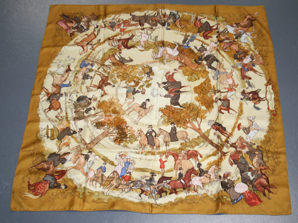 An Hermès silk scarf, titled `Les Amazones`, printed with figures on horseback, approx 89cm x 89cm.