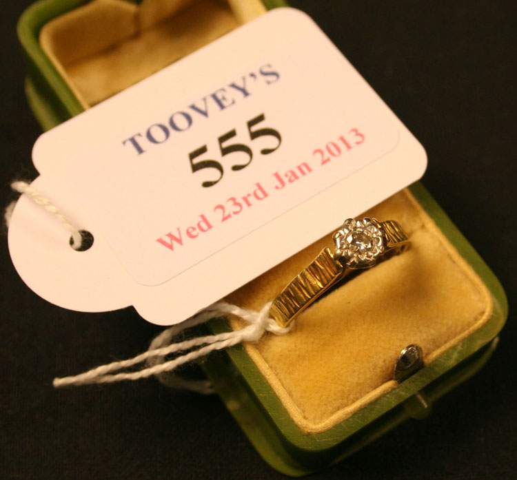 An 18ct gold and diamond set single stone ring, mounted with a circular cut diamond between cast and