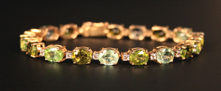 A 9ct gold, aquamarine, beryl, green tourmaline, peridot and colourless sapphire set line
