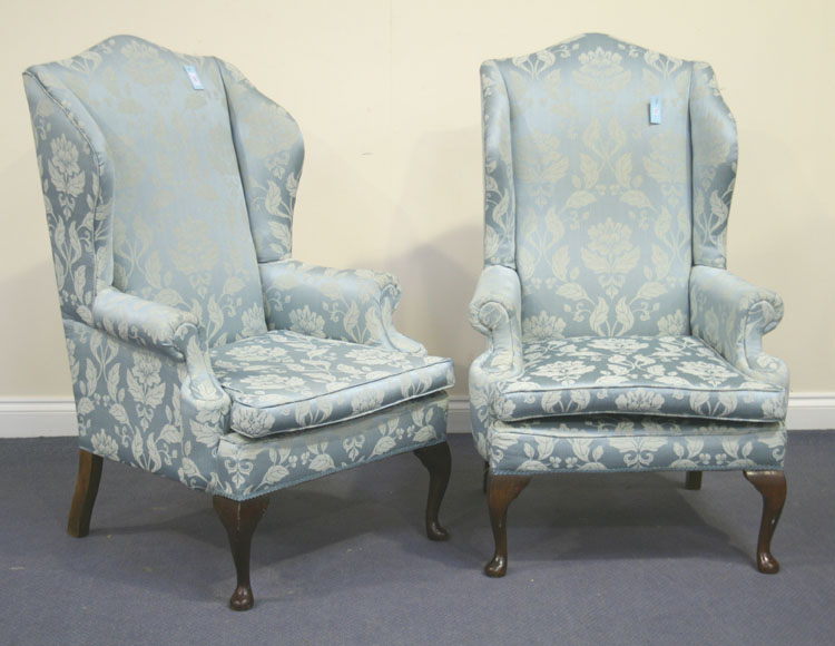 A pair of 20th Century George III style wing back and scroll armchairs, upholstered in patterned