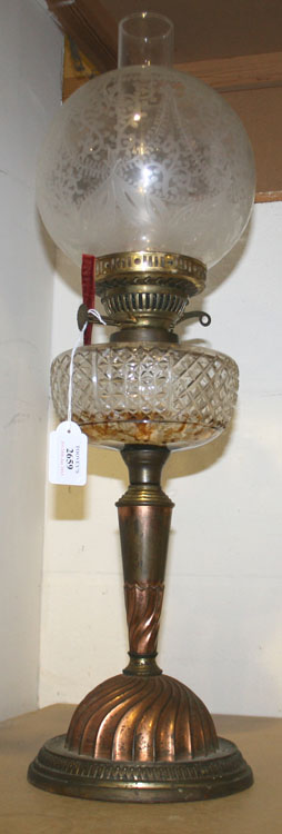 A late 19th/early 20th Century oil lamp with cut glass reservoir and etched glass shade, the