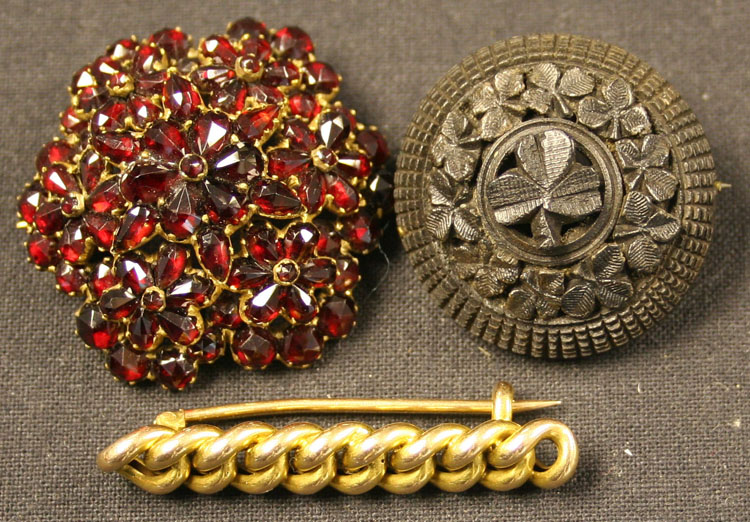 A Bohemian garnet set brooch in a hexagonal multiple floral cluster design, a gold bar brooch in a