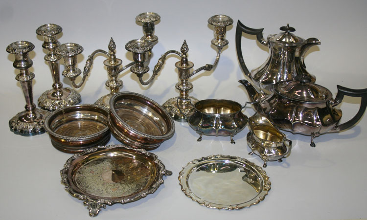 A collection of plated items, including a four piece tea service, a pair of candelabra, a pair of