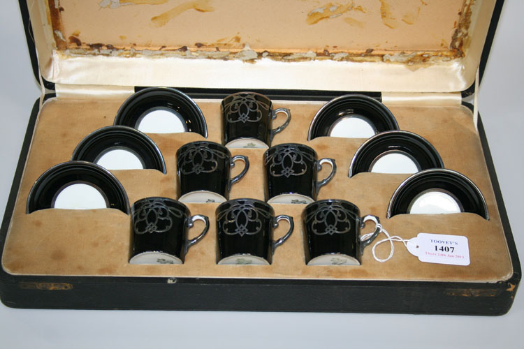 A set of six Aynsley bone china coffee cans and saucers, each black ground can with silver overlay