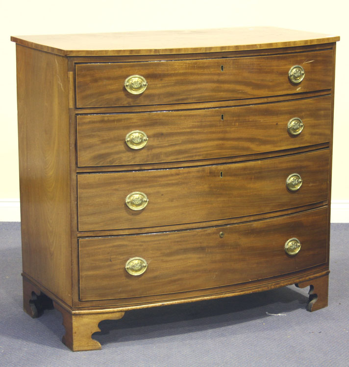 A George IV mahogany bowfront chest of four graduated long drawers, each brass handle with a