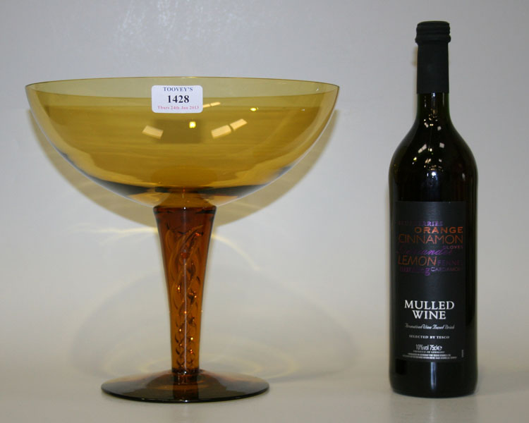 An amber tinted oversize champagne saucer, the generous bowl raised on an airtwist stem and circular