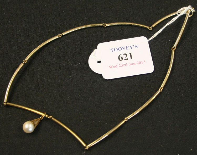 A 9ct gold necklace in a curved baton shaped link design, the front with a single gold capped