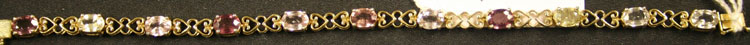 A 9ct gold and vari-coloured gem stone set line bracelet, mounted with eleven oval cut vari-coloured