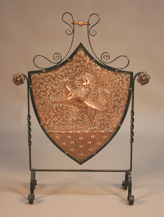 A late 19th Century Arts and Crafts style wrought iron and copper firescreen, the shield shaped