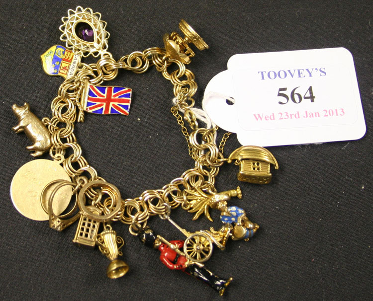 A gold charm bracelet in a triple circular link design, fitted with a variety of mostly 9ct gold
