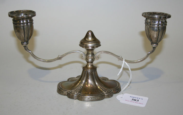 A silver twin scroll branch candelabrum, each lobed and reeded oval sconce flanking a central knop