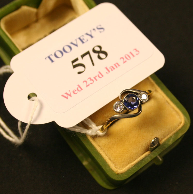 A gold, sapphire and diamond set three stone ring, mounted with a circular cut sapphire between