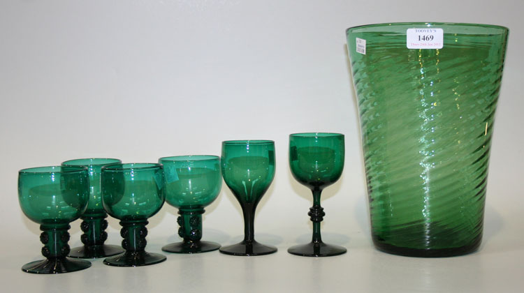 A flared green glass vase of spiral ribbed form in the style of Whitefriars, together with a set