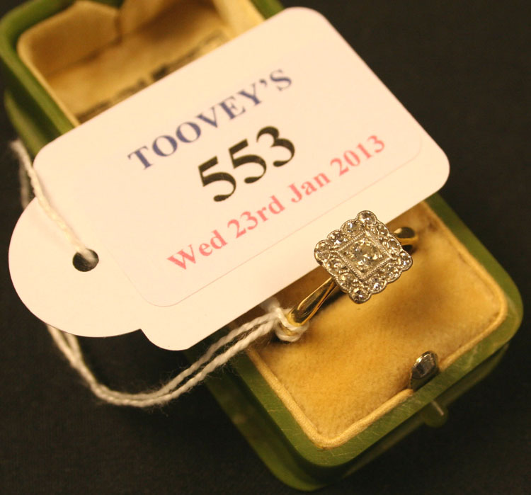 A gold, platinum and diamond square cluster ring, mounted with the principal circular cut diamond