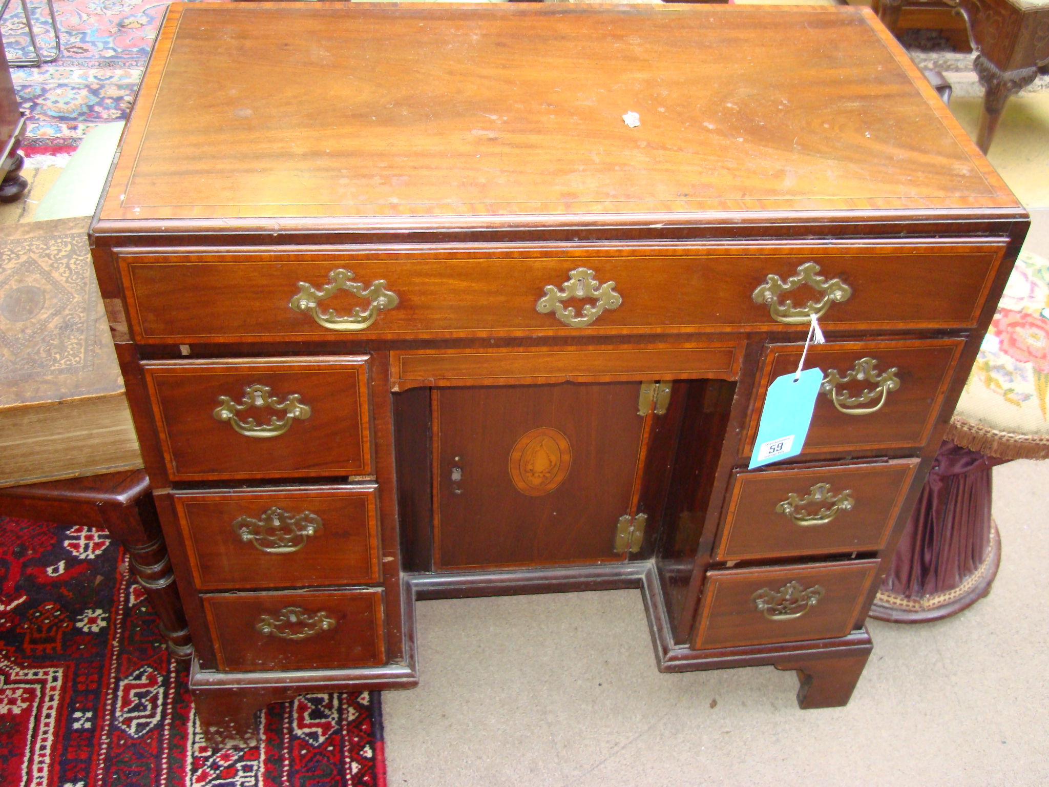 A George III mahogany kneehole desk, strung with ebony, crossbanded