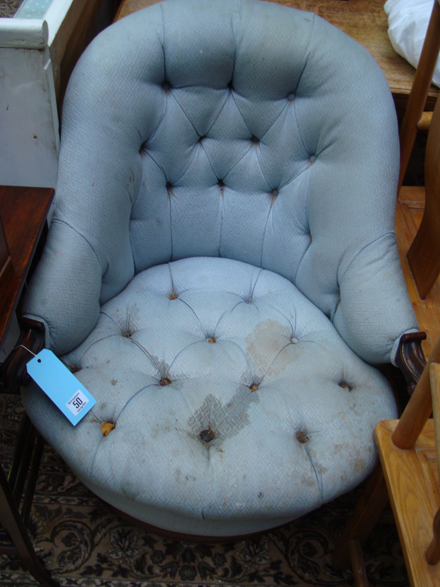 A late Victorian buttonback armchair with carved mahogany frame in the French Chippendale style