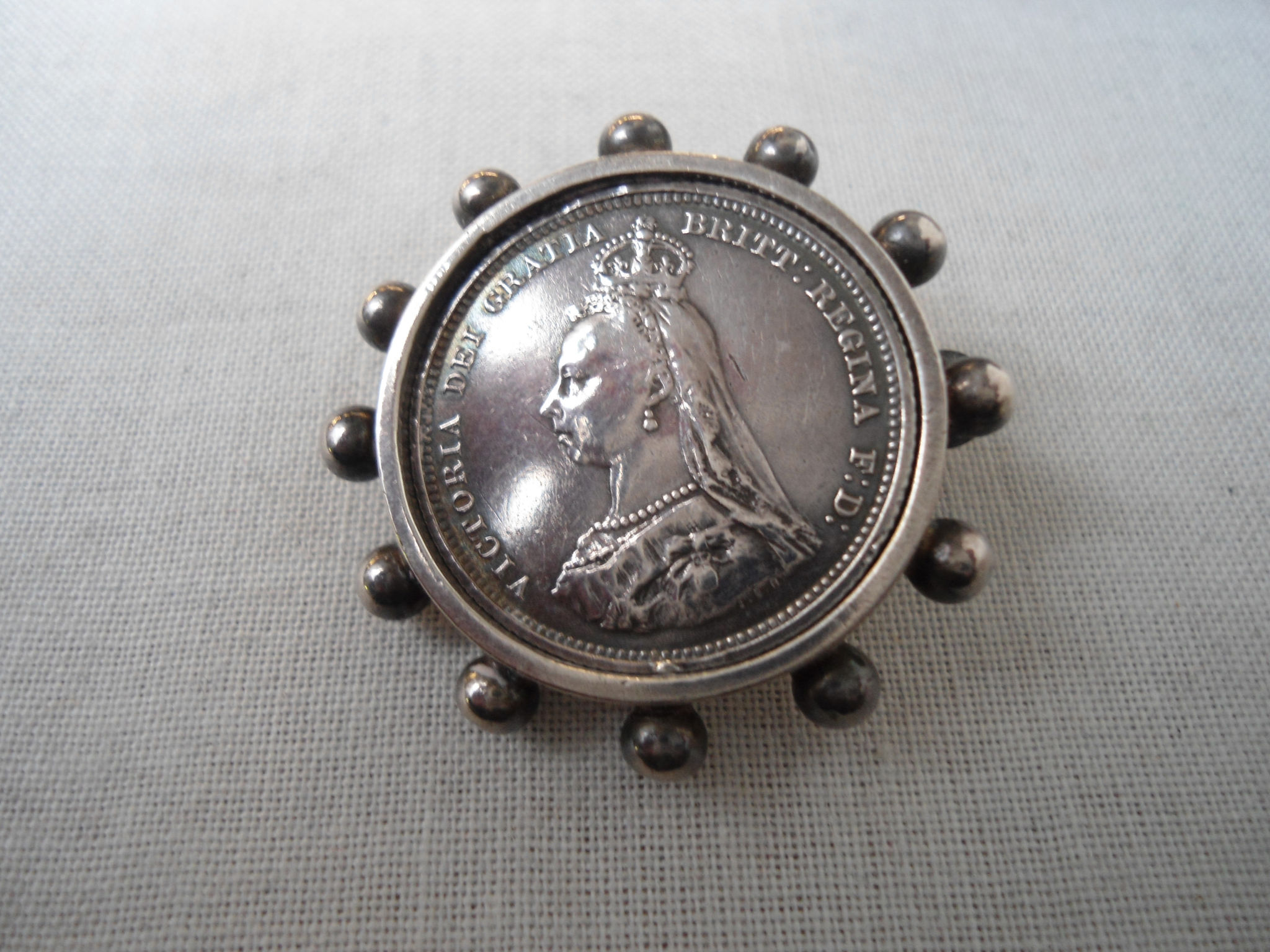 A Victorian silver shilling 1887 mounted as a brooch in silver