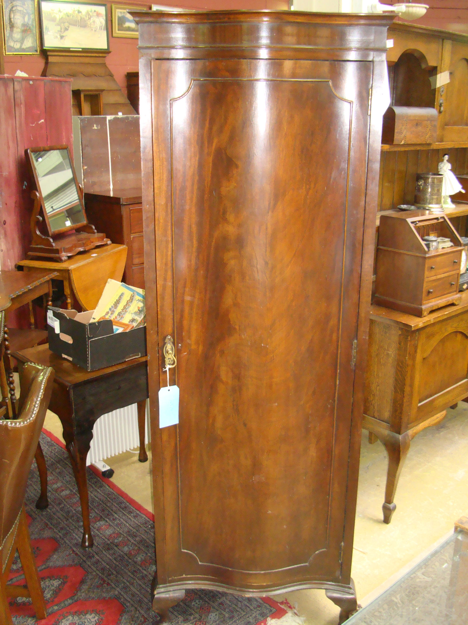 An early 20th century serpentine fronted mahogany style wardrobe