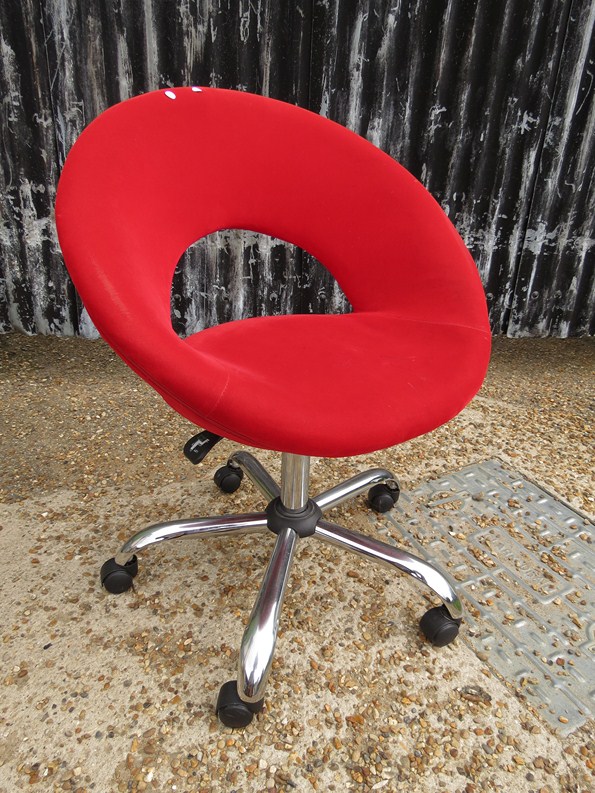 A modern office chair with red upholstery