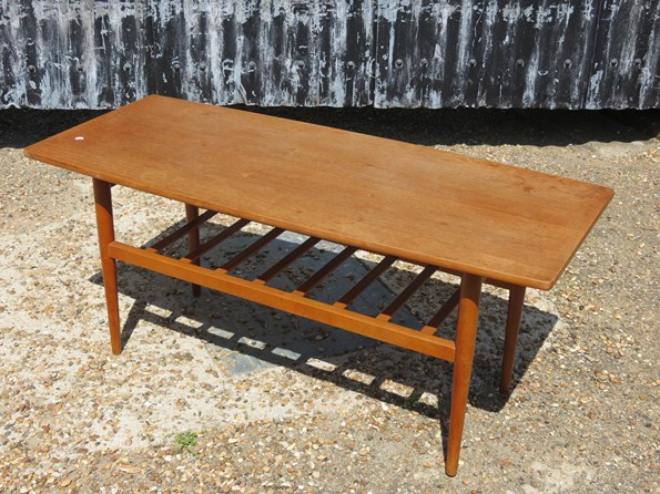 A teak coffee table with a slatted undertier, raised on tapering legs 105.5cm long x 45cm high x